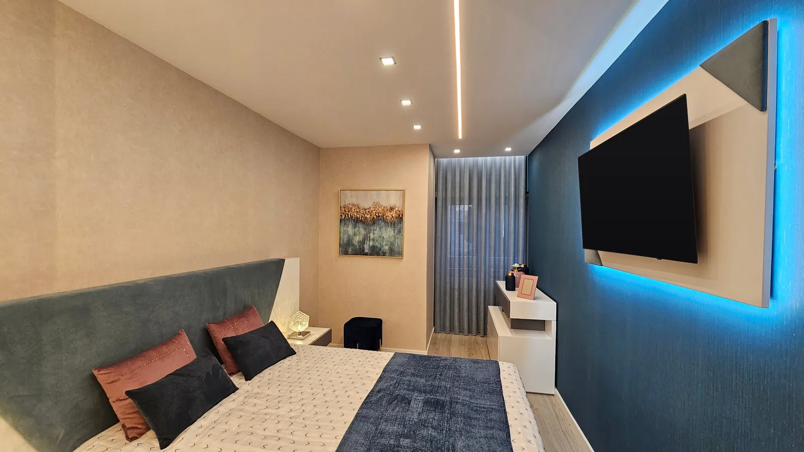 Quarto com parede azul iluminada por trás e cabeceira em painel.