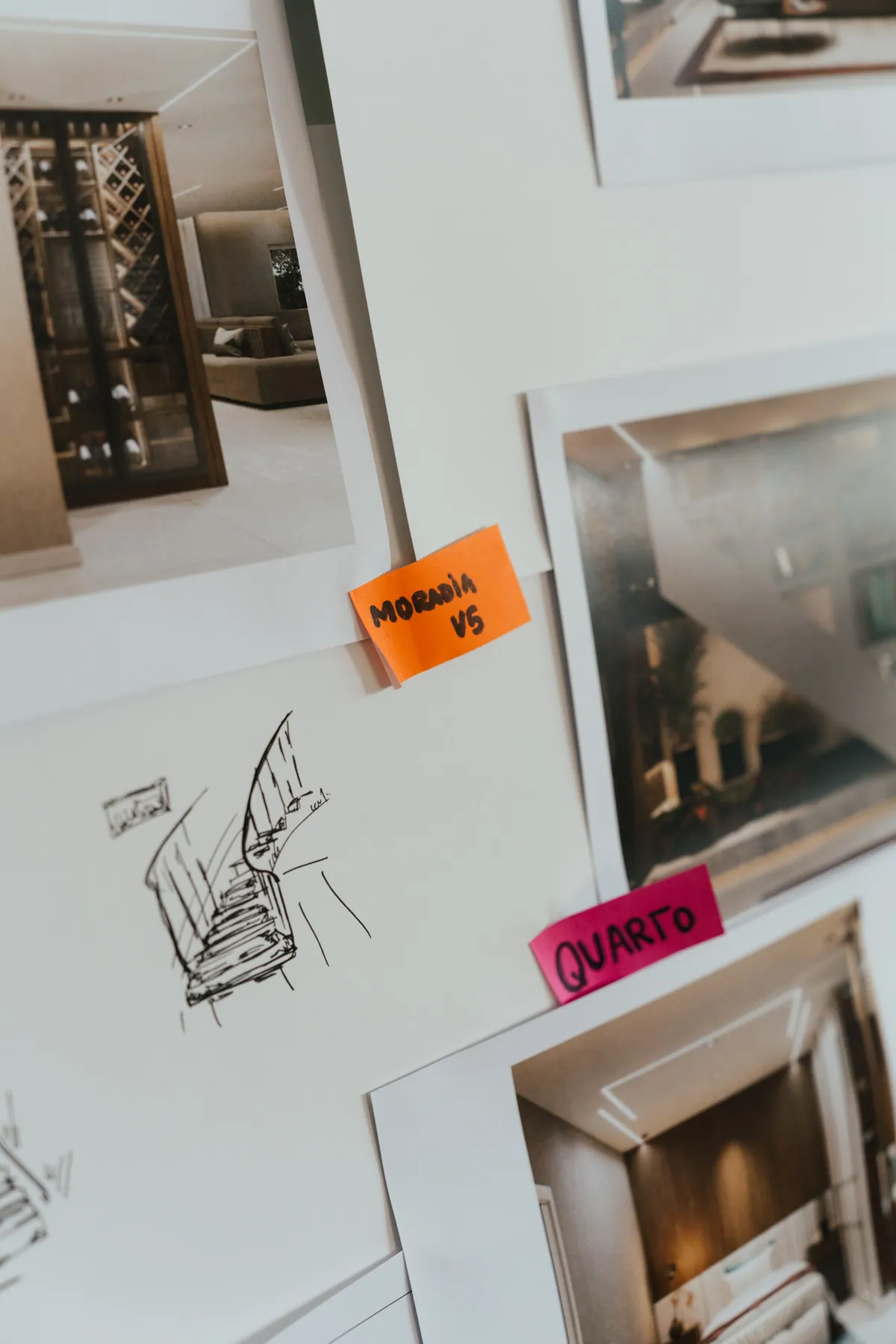Esboço da escada desenhado à mão entre renders e post-its na parede.