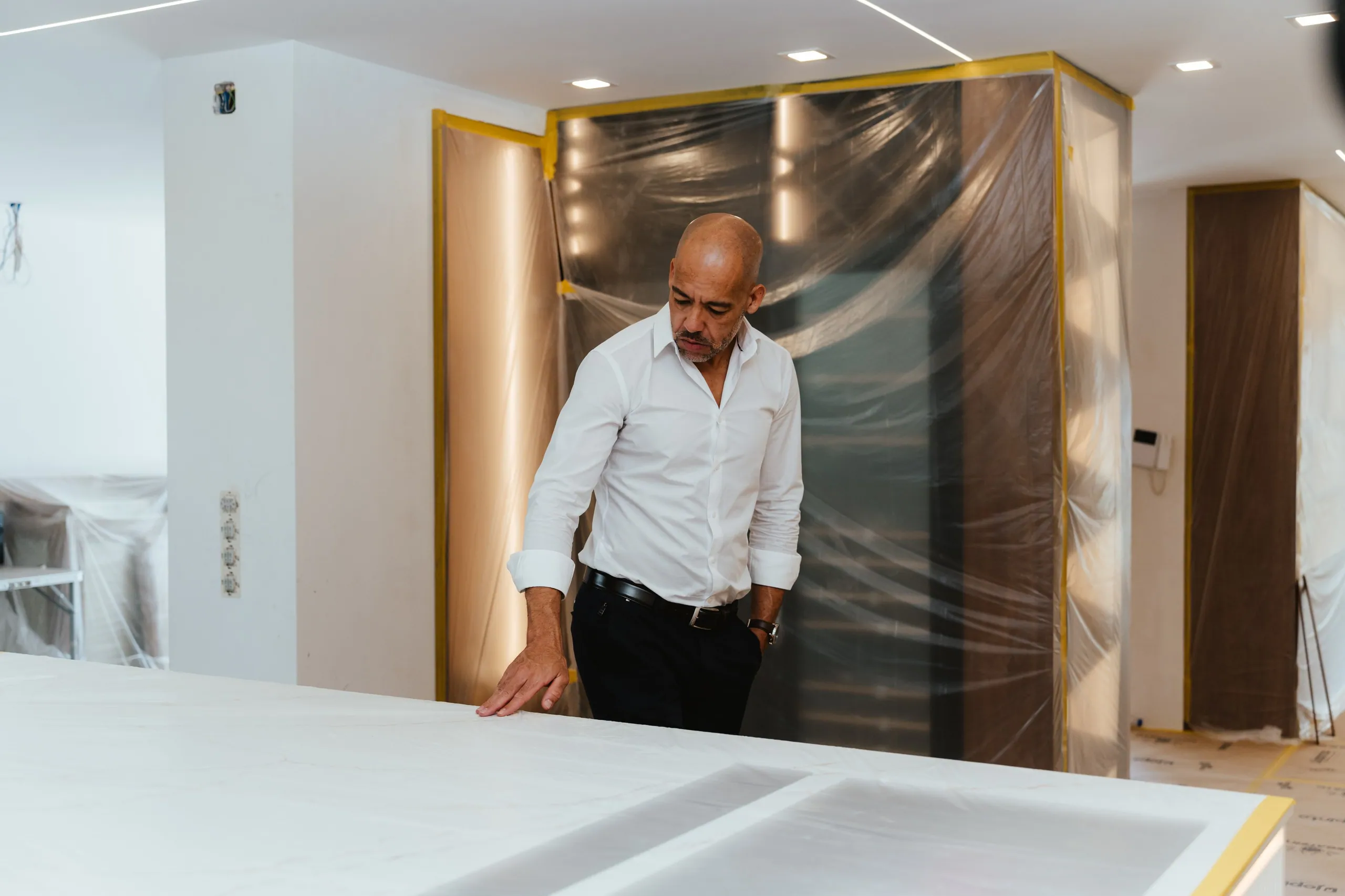 O Hernâni Meira na obra, debruçado sobre a bancada protegida da cozinha.