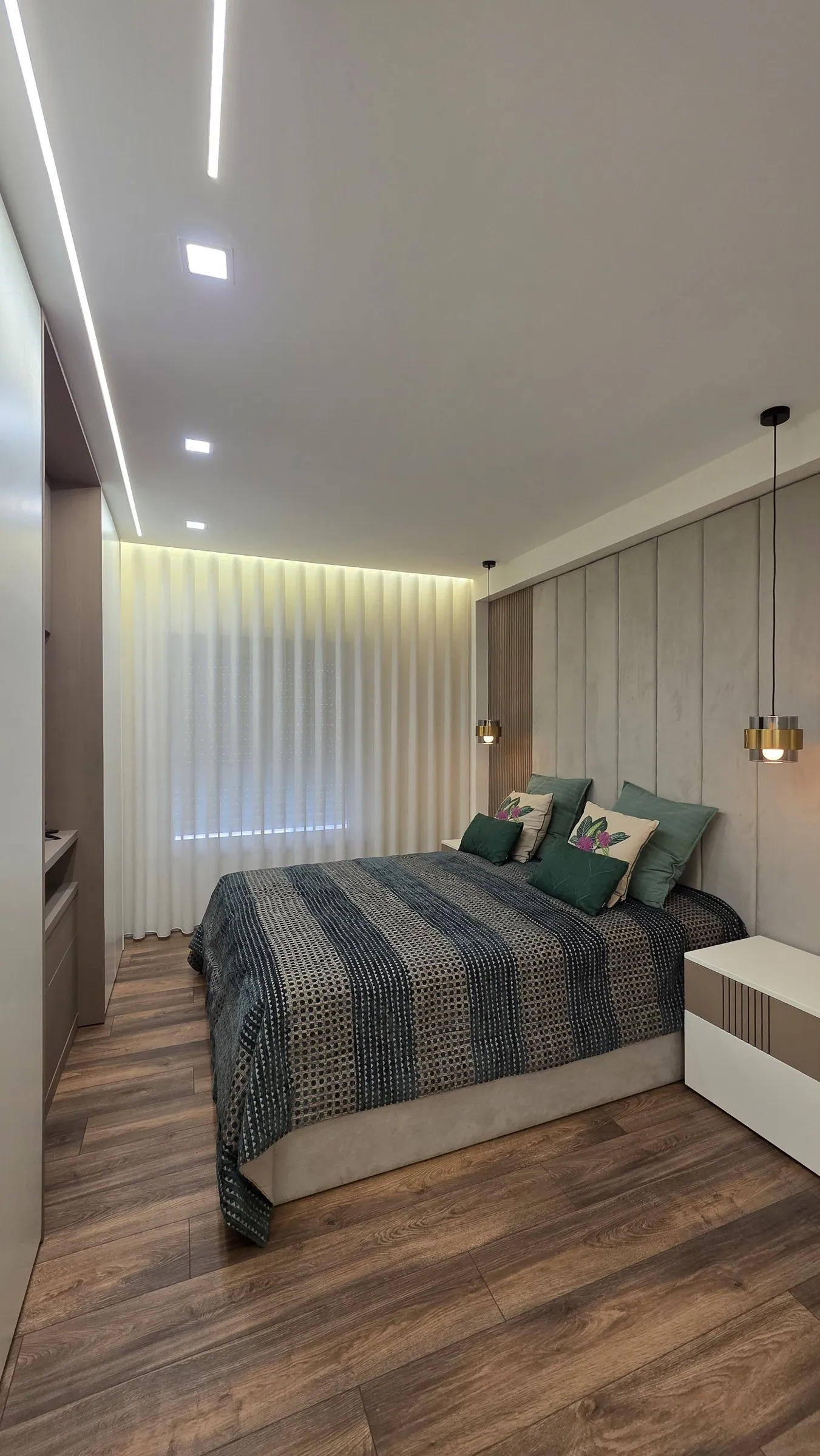 O quarto com cama de colcha listada.